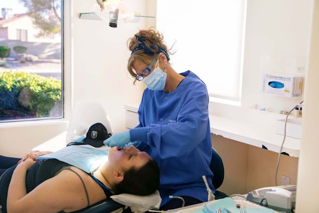 Hygienist performing cleaning treatment for a patient